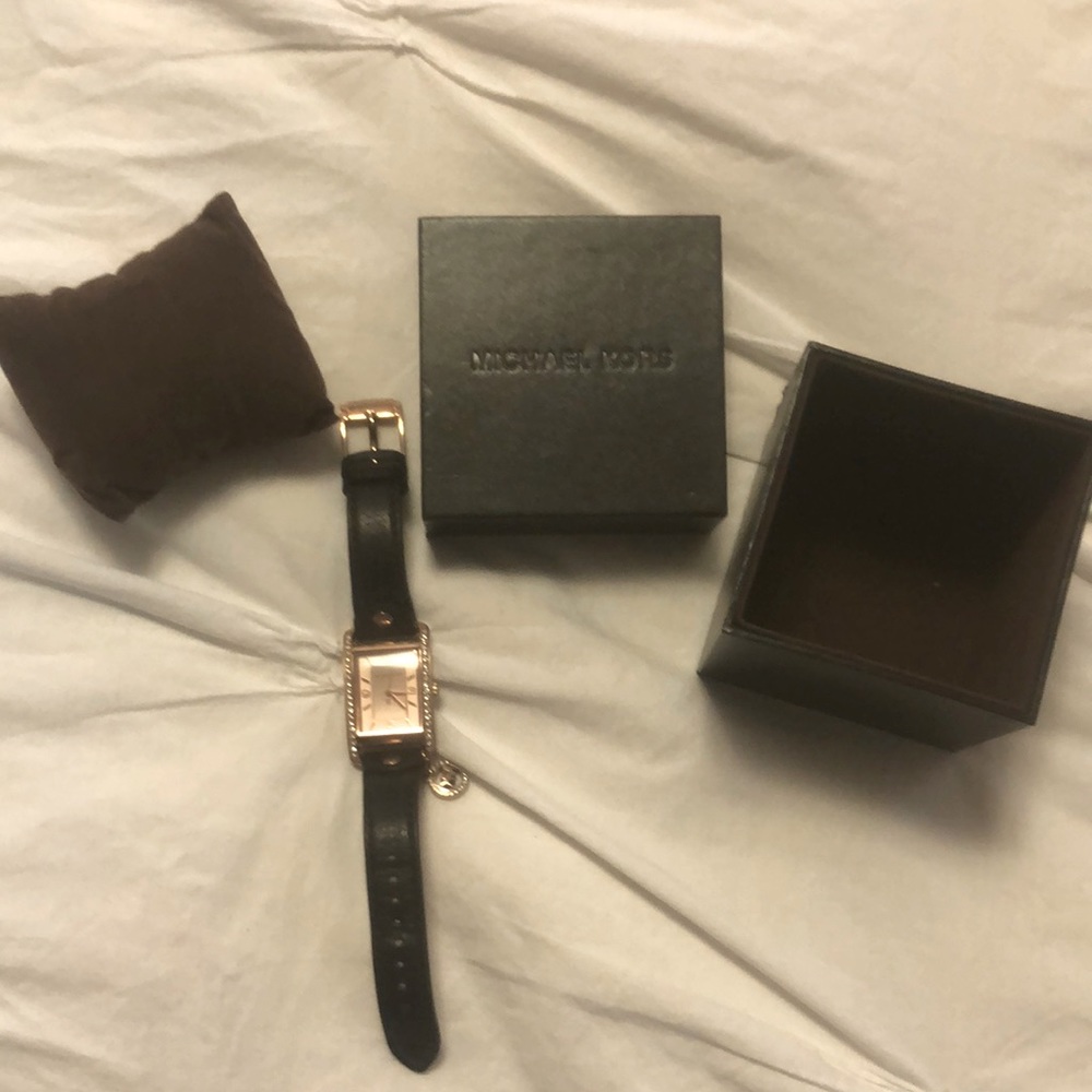 Michael Kors watch rose gold face with diamonds and dark brown leather band.